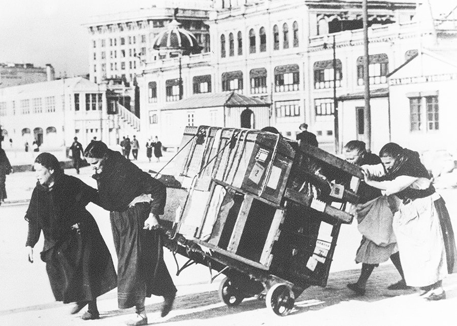 Asturian women carting immigrants’ trunks to the quay.