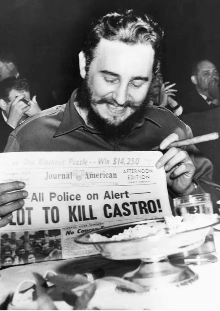 Fidel Castro holds up a newspaper headlining the discovery of a plot to kill Castro here, April 23rd. Castro was at the Overseas Press Club at the time.
