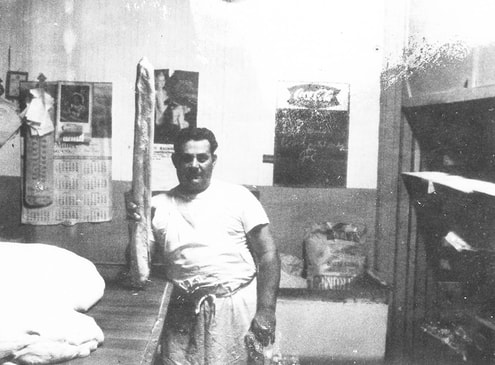 John Ferlita holding bread at his bakery (circa 1960)