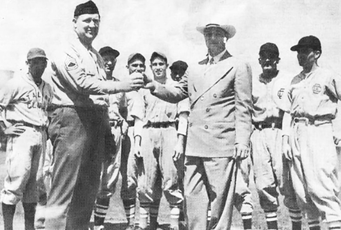 Sgt McGaughin hands the first baseball of the Intersocial League season to league president Antonio Castro